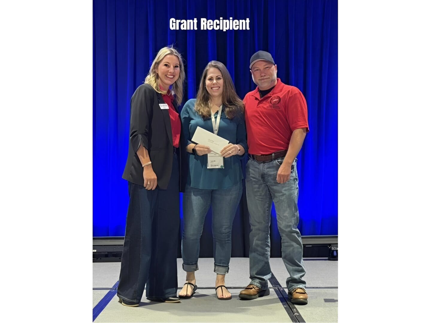 Grant recipient holding certificate on stage