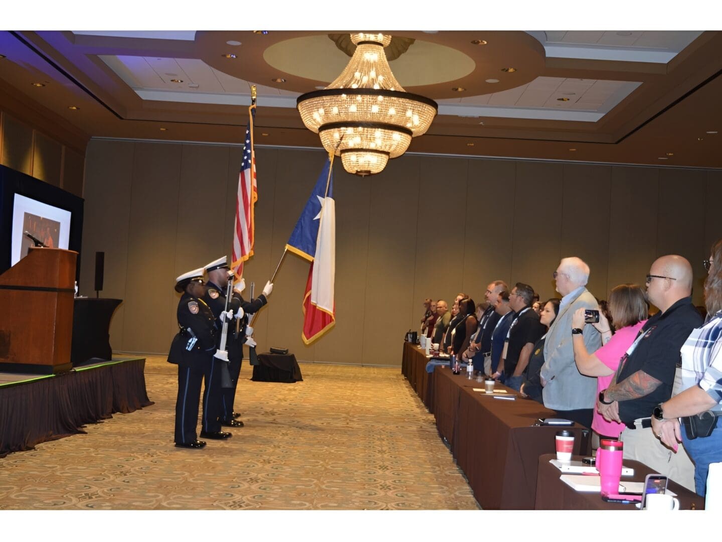 Standing attendees during flag presentation ceremony
