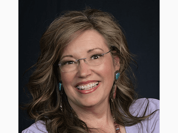 Smiling woman wearing glasses and earrings