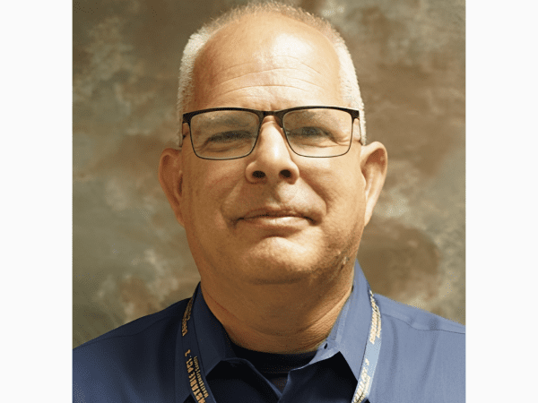 Portrait of man wearing glasses and lanyard