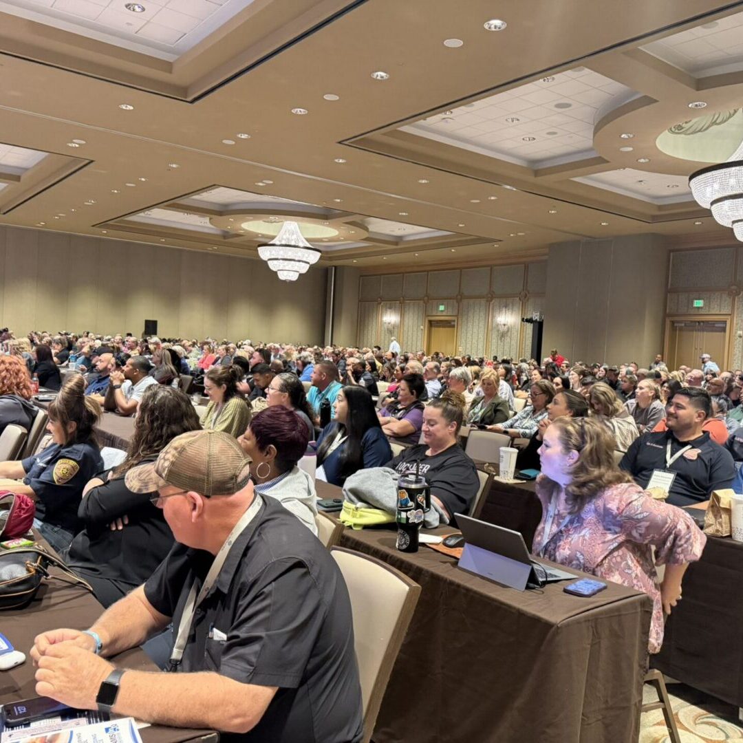 Attendees seated in ornate conference ballroom
