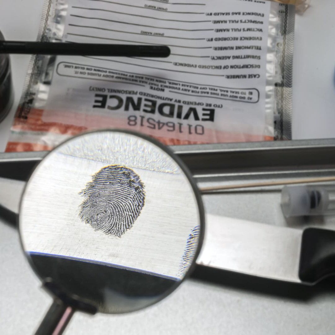 Fingerprint under magnifying glass, crime scene investigation.
